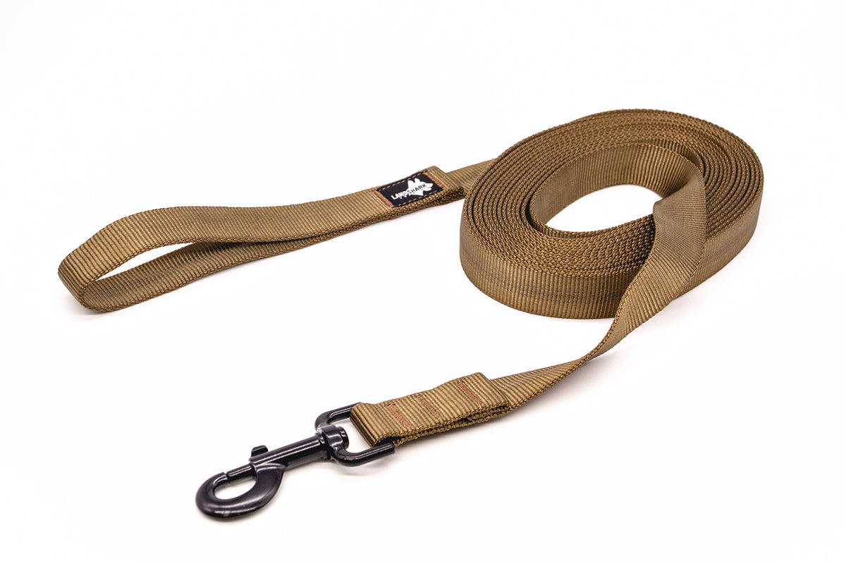 A Coyote Brown extra long dog leash with a black latch, curled up on a white background.