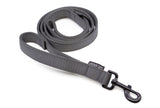 Curled up gray dog leash with black latch and sewn-on traffic handle on a white background