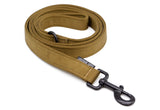 Curled up Coyote Brown dog leash with black latch on a white background