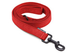 Curled up red dog leash with black latch on a white background