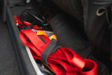 A dog leashed securely wrapped with an elastic band inside of a car door
